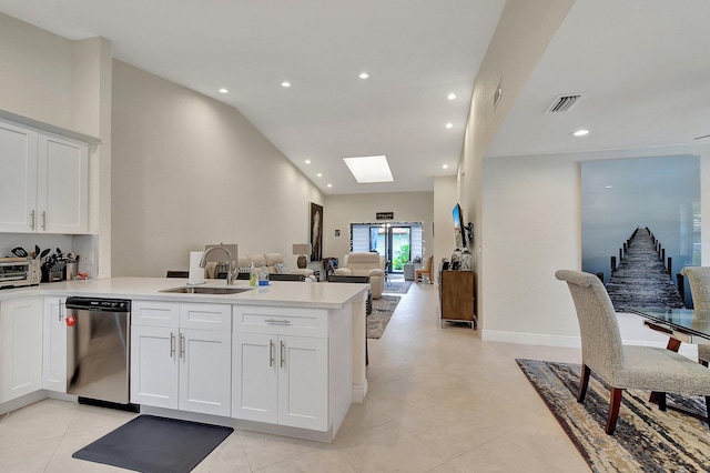 kitchen with kitchen peninsula, sink, light tile patterned floors, stainless steel dishwasher, and white cabinetry