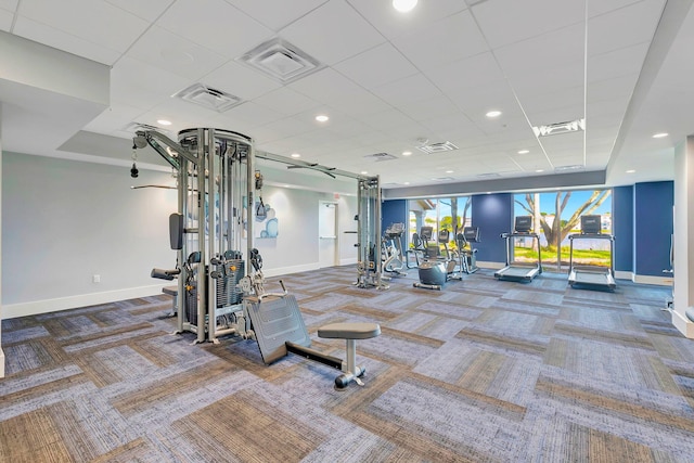 exercise room featuring carpet floors and a paneled ceiling