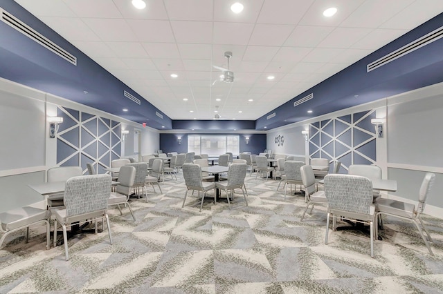 dining area featuring carpet floors and a drop ceiling