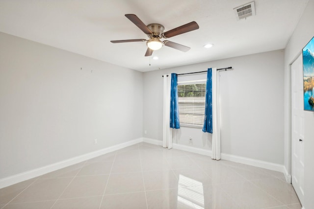 spare room with ceiling fan and light tile patterned floors