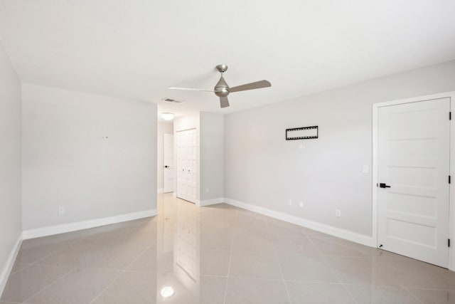 tiled spare room with ceiling fan