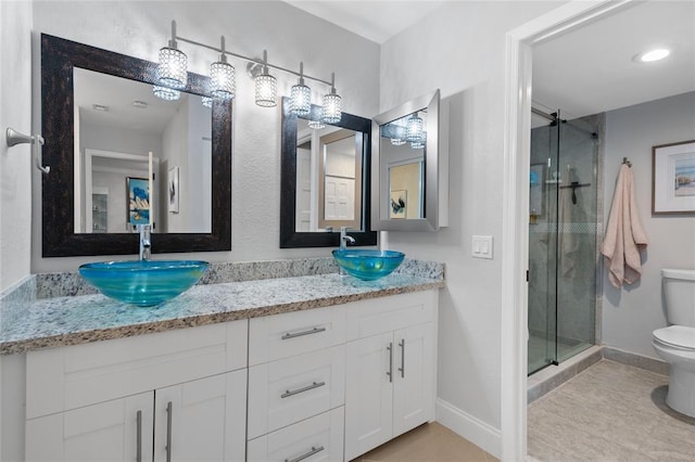 bathroom with toilet, vanity, walk in shower, and tile patterned floors