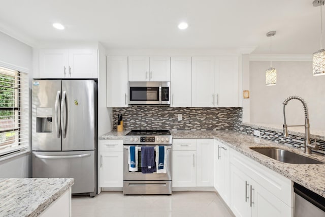 kitchen featuring tasteful backsplash, appliances with stainless steel finishes, white cabinetry, sink, and crown molding