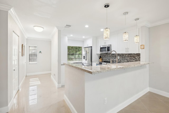 kitchen featuring backsplash, hanging light fixtures, white cabinetry, appliances with stainless steel finishes, and kitchen peninsula