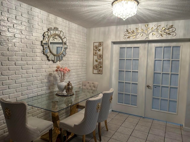 dining room featuring a textured ceiling, a notable chandelier, french doors, and light tile patterned flooring