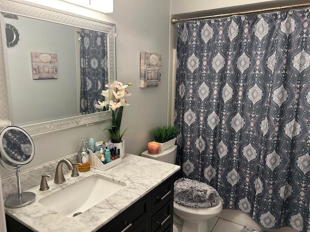 bathroom featuring tile patterned flooring, vanity, toilet, and walk in shower