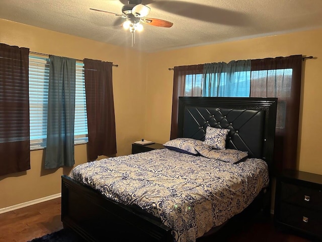 bedroom with dark wood-type flooring, a textured ceiling, and ceiling fan