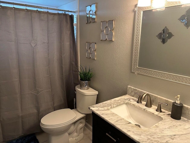 bathroom featuring tile patterned flooring, vanity, and toilet