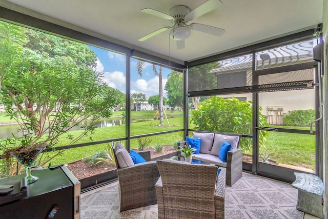 sunroom / solarium with a water view and ceiling fan