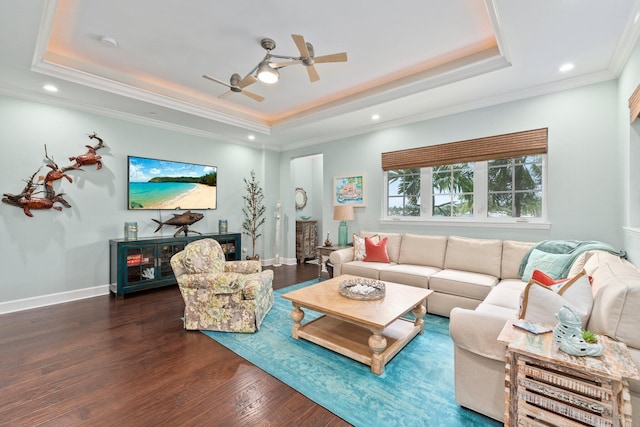 living room featuring crown molding, a raised ceiling, ceiling fan, and dark wood-type flooring