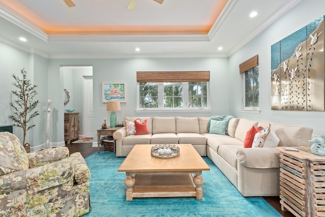 living room featuring crown molding, hardwood / wood-style flooring, a tray ceiling, and ceiling fan