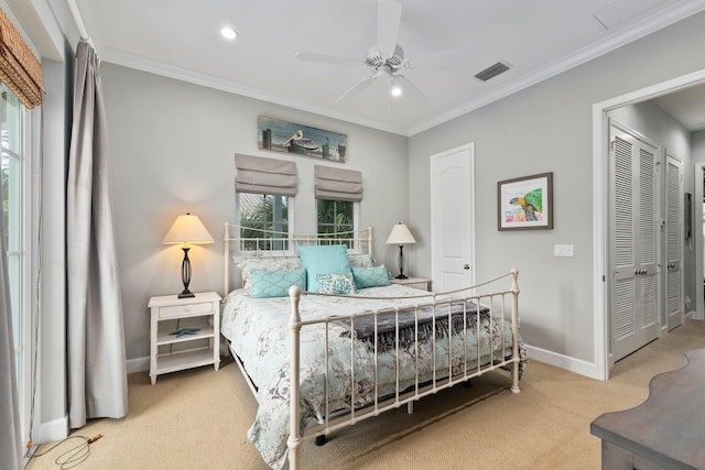 carpeted bedroom featuring crown molding, ceiling fan, and a closet