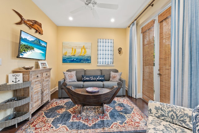 living room featuring ceiling fan and dark hardwood / wood-style floors