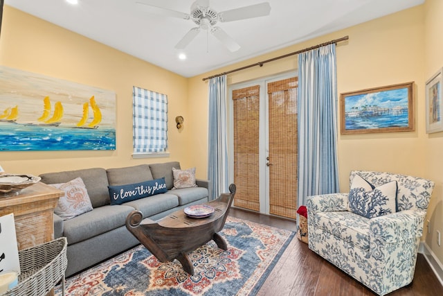 living room featuring ceiling fan and dark hardwood / wood-style flooring