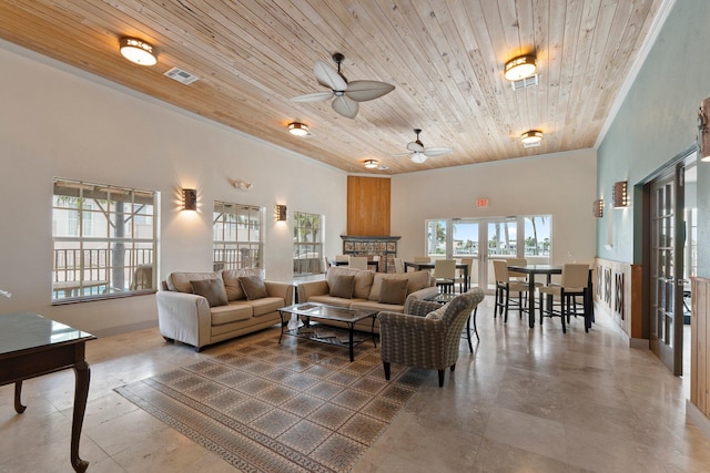 living room featuring a high ceiling, ceiling fan, wood ceiling, and a fireplace