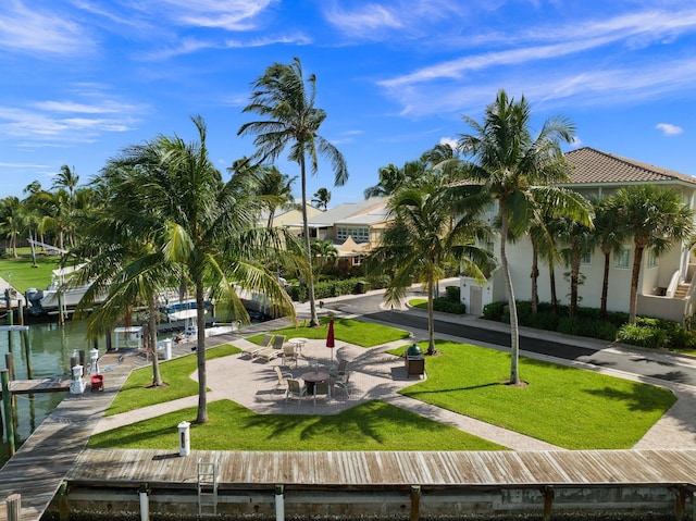 view of property's community with a water view and a lawn