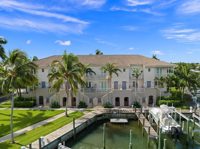 view of dock with a water view and a lawn