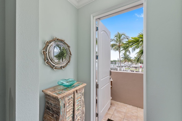 doorway with ornamental molding and light tile patterned floors