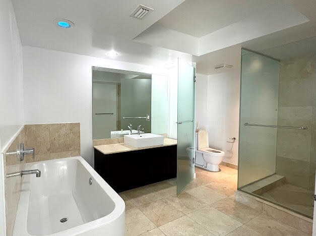 full bathroom featuring tile patterned floors, independent shower and bath, vanity, and toilet