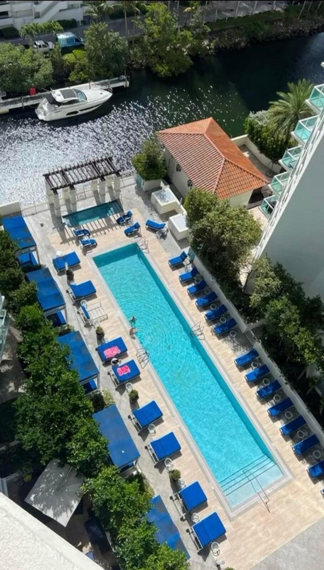 view of swimming pool featuring a patio area and a water view