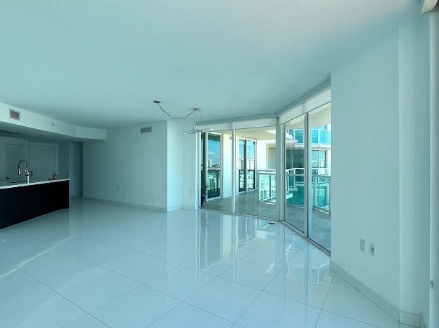 empty room with sink, expansive windows, and light tile patterned floors