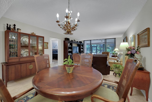 tiled dining area featuring an inviting chandelier and a textured ceiling