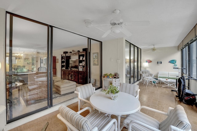 interior space featuring expansive windows and ceiling fan with notable chandelier