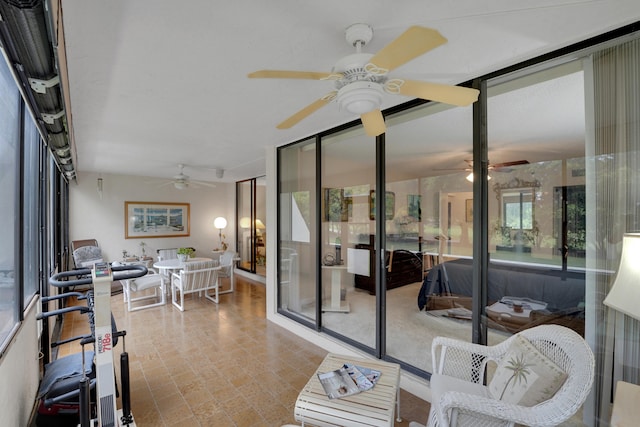 sunroom / solarium featuring ceiling fan