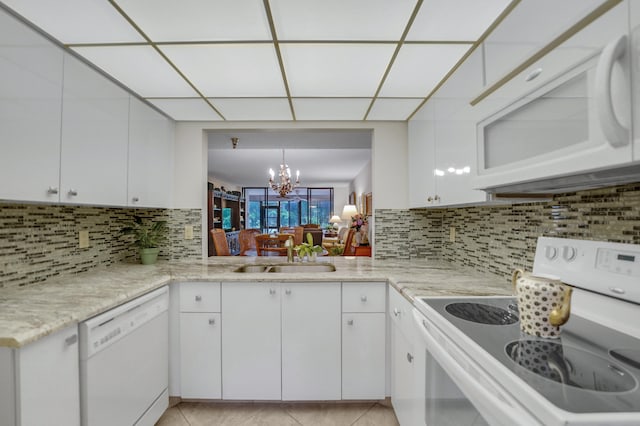 kitchen featuring sink, white appliances, light tile patterned floors, and tasteful backsplash