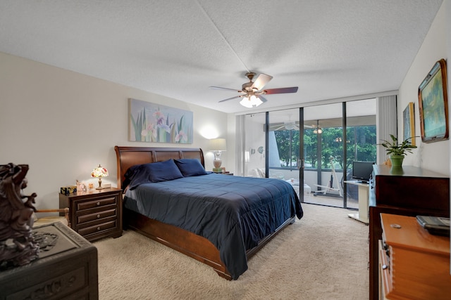 carpeted bedroom with ceiling fan, a wall of windows, a textured ceiling, and access to exterior