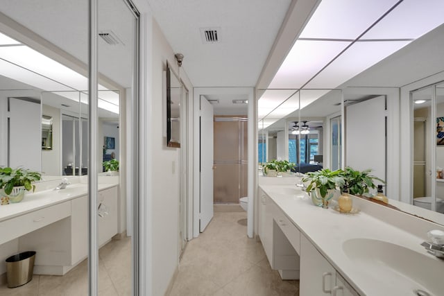 bathroom featuring an enclosed shower, tile patterned flooring, vanity, ceiling fan, and toilet