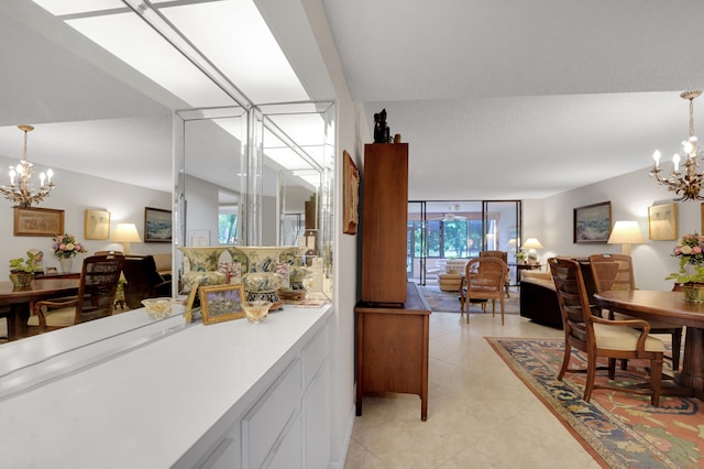 kitchen featuring white cabinets, a notable chandelier, a wall of windows, and light tile patterned floors