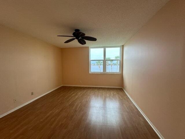 unfurnished room with ceiling fan, hardwood / wood-style flooring, and a textured ceiling