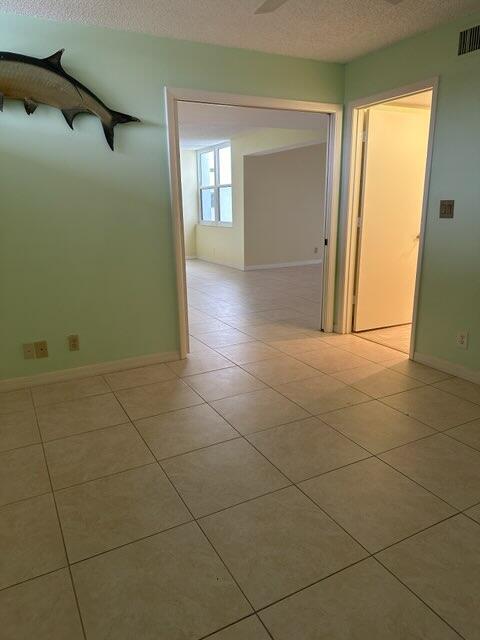 tiled spare room with a textured ceiling