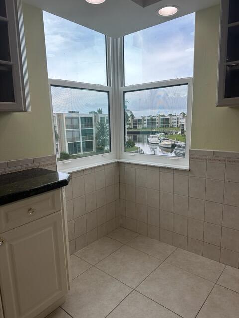 interior space featuring light tile patterned floors, white cabinets, and tile walls