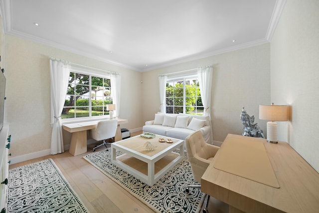 living area with baseboards, light wood-type flooring, and ornamental molding
