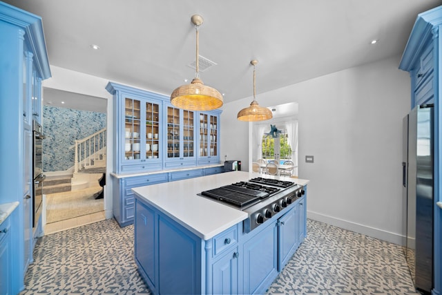 kitchen featuring blue cabinets, visible vents, a center island, light countertops, and stainless steel gas cooktop