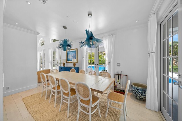 dining area featuring french doors, light hardwood / wood-style flooring, and crown molding