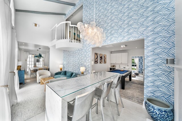 dining space featuring beam ceiling, a wealth of natural light, and high vaulted ceiling