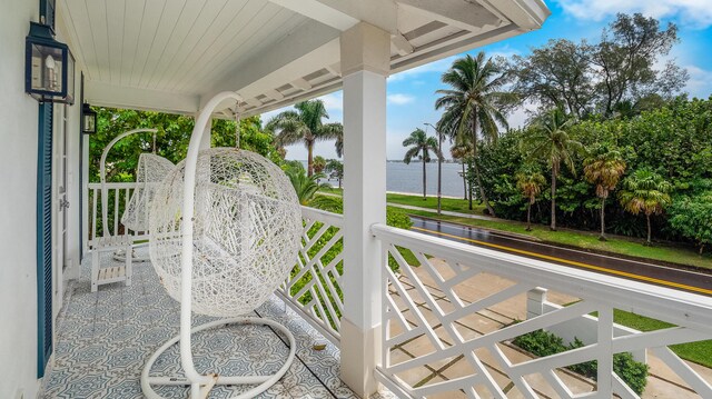 balcony featuring covered porch and a water view