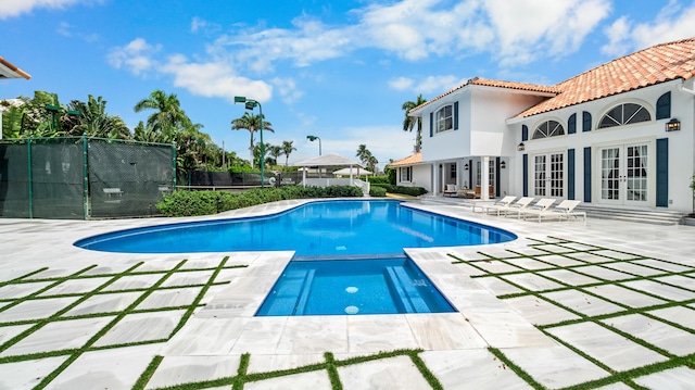 view of swimming pool with a patio area and french doors