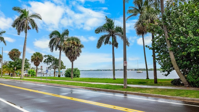 view of street featuring sidewalks, traffic signs, and a water view