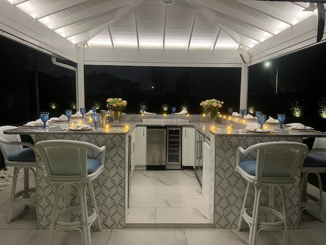 7515-7425 S Flagler Dr, West Palm Beach, FL 33405 - patio at night featuring beverage cooler, a bar, and a gazebo