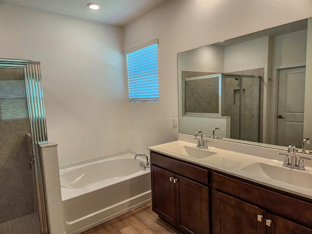 bathroom with hardwood / wood-style floors, vanity, and separate shower and tub