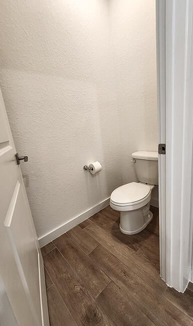 bathroom featuring wood-type flooring and toilet