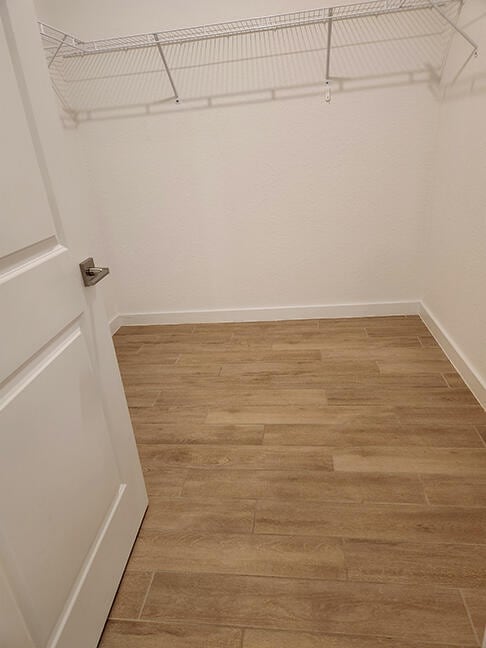 walk in closet with hardwood / wood-style flooring