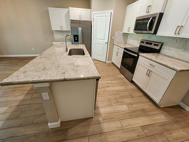 kitchen featuring a center island with sink, white cabinets, and appliances with stainless steel finishes