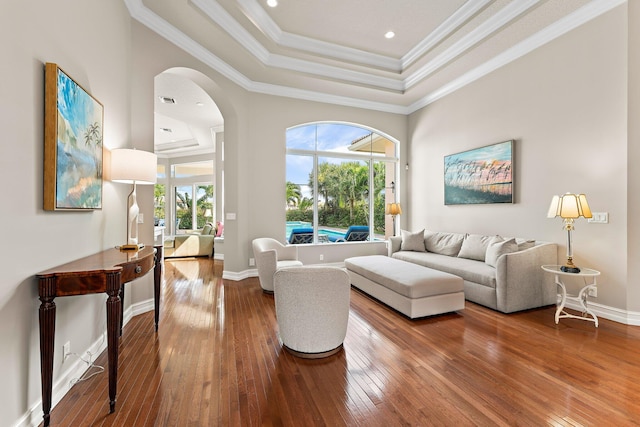 living room featuring crown molding, a raised ceiling, and hardwood / wood-style flooring