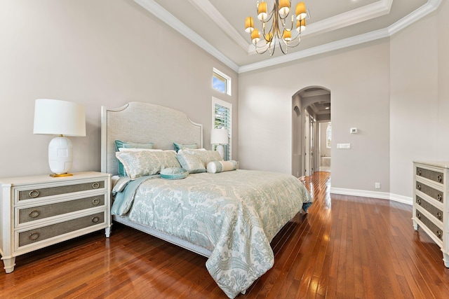 bedroom with a raised ceiling, hardwood / wood-style flooring, crown molding, and a notable chandelier