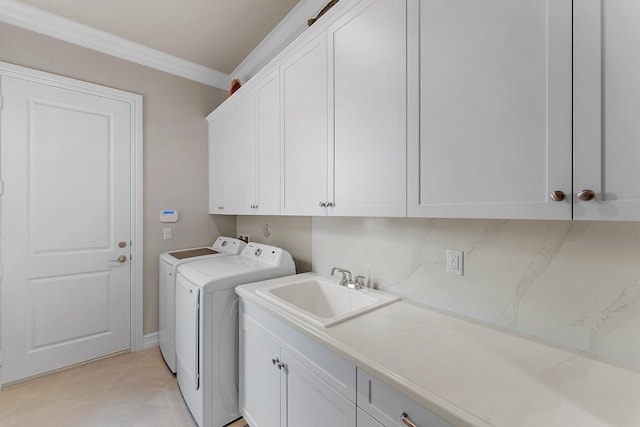 laundry room with ornamental molding, sink, cabinets, washer and dryer, and light tile patterned floors